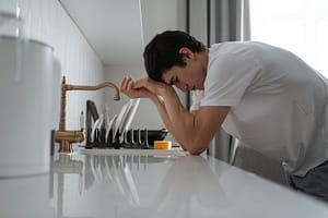 man leaning on the kitchen counter
