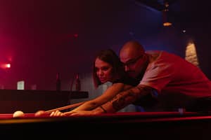 man and a woman playing billiards
