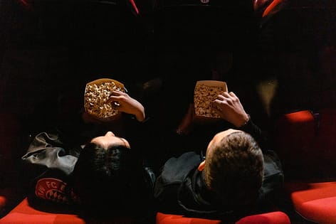 people eating popcorn at a cinema