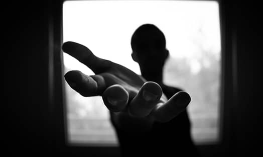 man s hand in shallow focus and grayscale photography