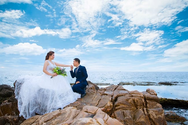newlywed couple on mount near sea on wedding day