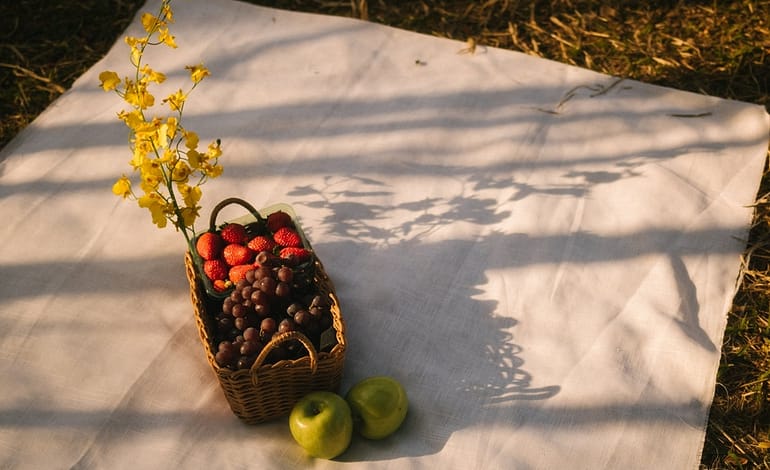 basket of fruit on white cloth