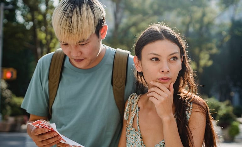 young diverse lost couple finding route in map