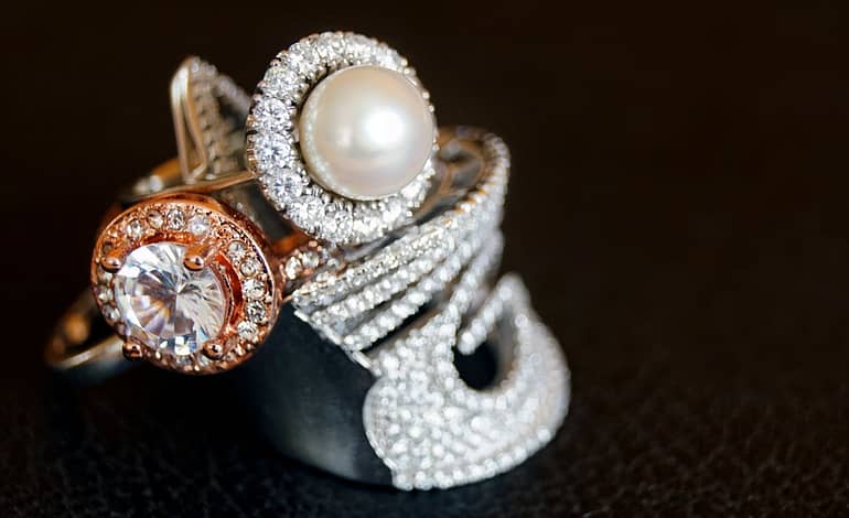 silver colored ring with clear gemstone and white pearl