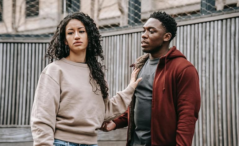 multiethnic couple having quarrel on street